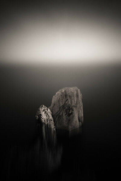 A monochromatic masterpiece from Davide Esposito's "Archetypes" series, featuring primordial symbols of rocks and sea.