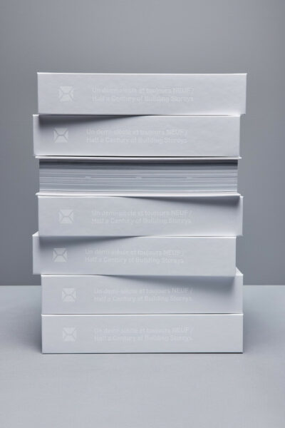 Stacked books representing "Half a Century of Building Storeys."