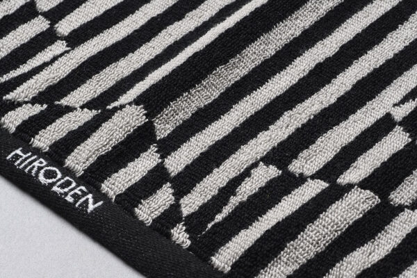 Striking black and white close-up of the HIROSHIMA DENTETSU TOWEL, emphasizing its timeless and elegant design.