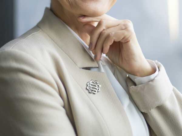 Grand Chasseral logo as a brooch on a suit