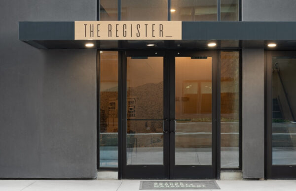 Entrance doors featuring The Register branding and graphics from street view