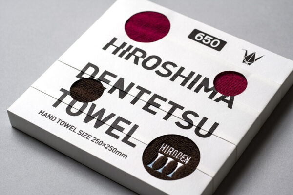 Detailed close-up of the HIROSHIMA DENTETSU TOWEL, showcasing intricate design elements and product packaging.